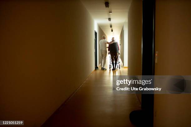 In this photo illustration A geriatric nurse helps an old man with a walker on June 11, 2020 in Bonn, Germany.