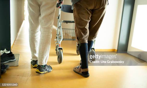 In this photo illustration A geriatric nurse helps an old man with a walker on June 11, 2020 in Bonn, Germany.