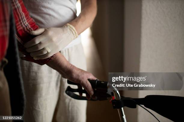 In this photo illustration a geriatric nurse helps an old man with a walker on June 11, 2020 in Bonn, Germany.