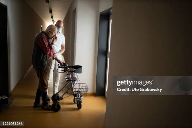 In this photo illustration A geriatric nurse helps an old man with a walker on June 11, 2020 in Bonn, Germany.