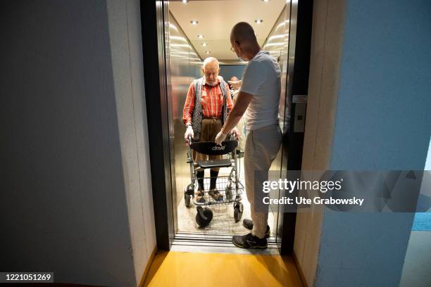 In this photo illustration a nurse helps a man in an elevator on June 11, 2020 in Bonn, Germany.