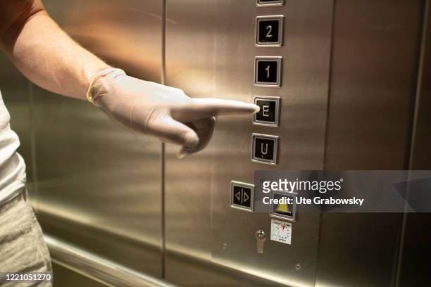 In this photo illustration a hand with a glove is pressing a button in an elevator on June 11, 2020 in Bonn, Germany.