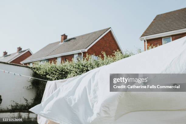 white sheet on washing line - sheet bedding stock-fotos und bilder