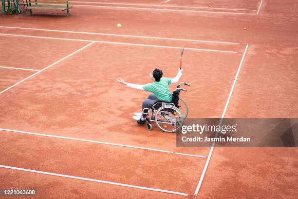 teenage boy in wheelchair playing tennis - sports activity stock pictures, royalty-free photos & images