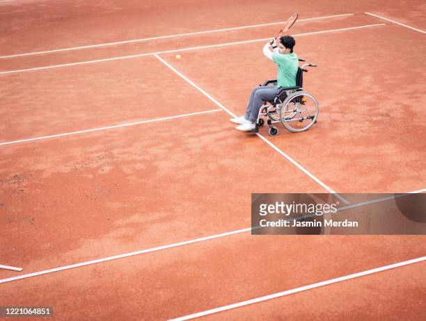 Teenage boy in wheelchair playing tennis