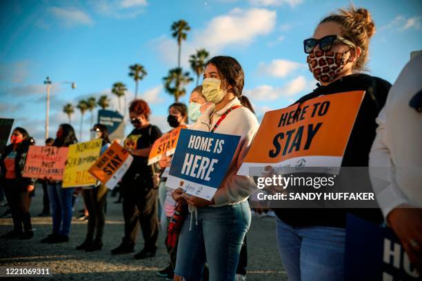 People hold signs during a rally in support of the Supreme Court's ruling in favor of the Deferred Action for Childhood Arrivals program, in San...