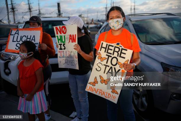 People hold signs during a rally in support of the Supreme Court's ruling in favor of the Deferred Action for Childhood Arrivals program, in San...
