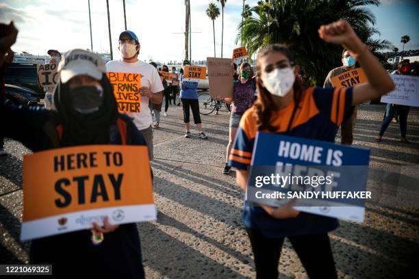 People hold signs during a rally in support of the Supreme Court's ruling in favor of the Deferred Action for Childhood Arrivals program, in San...