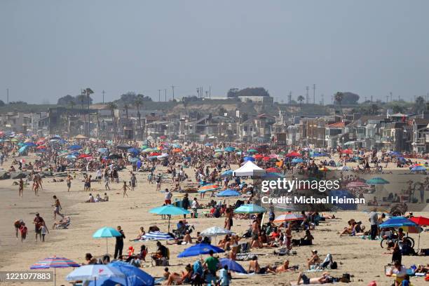 People are seen gathering on the beach north of Newport Beach Pier on April 25, 2020 in Newport Beach, California. Southern California is expecting...