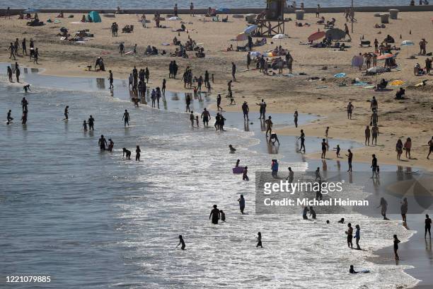 People are seen gathering on the Corona del Mar State Beach on April 25, 2020 in Newport Beach, California. Southern California is expecting summer...