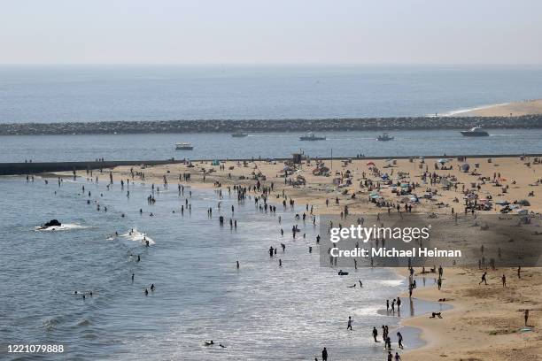 People are seen gathering on the Corona del Mar State Beach on April 25, 2020 in Newport Beach, California. Southern California is expecting summer...