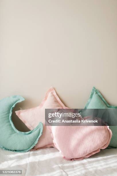 linen blue and pink moon and star shaped pillow toy on light bedding over beige background. decorative baby pillows on nursery. - mini moon stock pictures, royalty-free photos & images