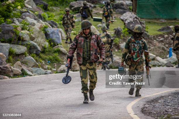 Indian Border Security Force soldiers patrol a highway as Indian army convoy passes through on a highway leading towards Leh, bordering China, on...