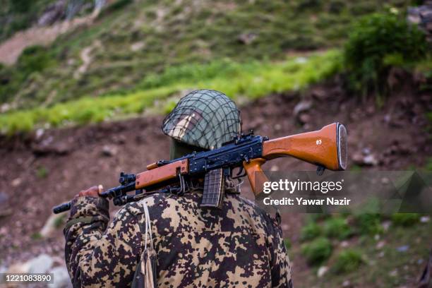 An Indian Border Security Force soldier guards a highway as Indian army convoy makes way towards Leh, bordering China, on June 19, 2020 in Gagangir,...
