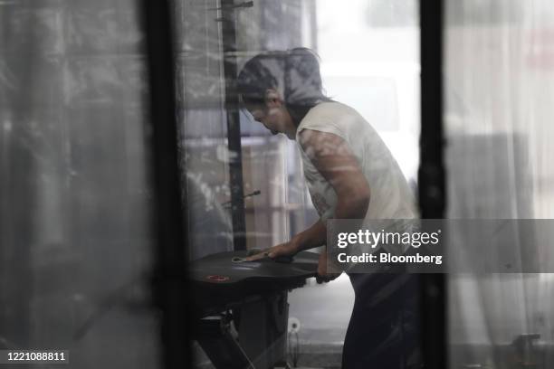 Person disinfects a yoga mat inside a temporary social distancing pod at Inspire South Bay Fitness in Redondo Beach, California, U.S., on Friday,...