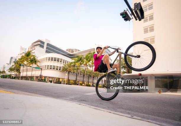 doing wheelie bike style in miami beach - wheelie stock pictures, royalty-free photos & images