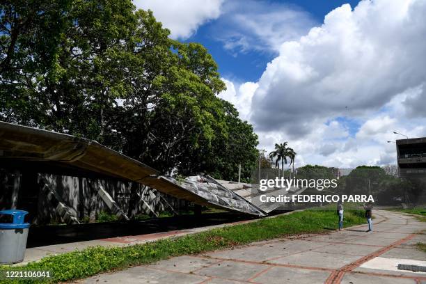 Venezuelan university students record a video with their cell phone next to a collapsed roof of the Central University of Venezuela in Caracas, on...