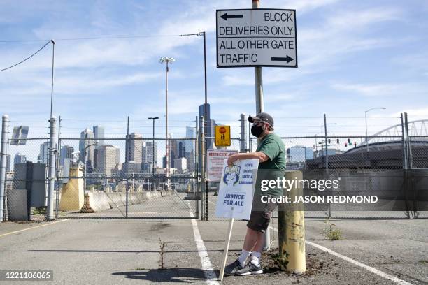 Man stands near closed Terminal 46 gates during the "Juneteenth Shutdown of All Pacific Coast Ports" rally and march event organized by Seattle's A....