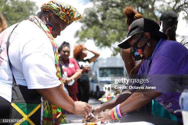 Nikki Brown buys food from Joyce Childs during the Black Lives Matters Business Expo on June 19, 2020 in St. Petersburg, Florida. The St. Petersburg...