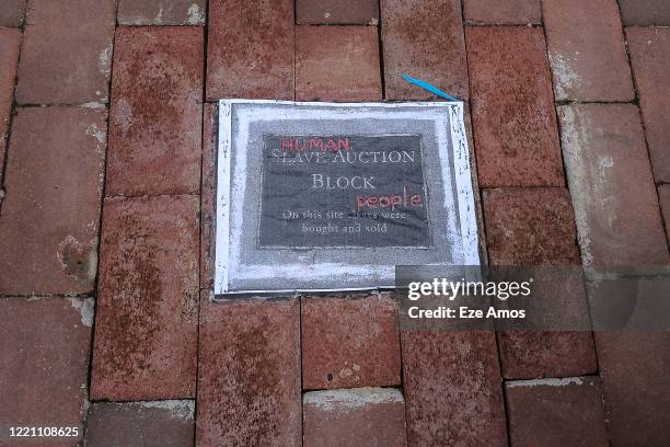Vandalized plaque on the original site of Charlottesvilles auction block where the enslaved were sold is seen on June 19, 2020 in Charlottesville,...