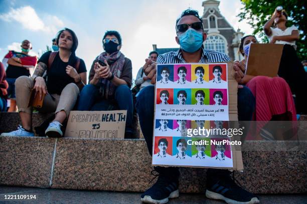 Man wearing a mouth mask is holding a placard with the images of Sarah Hegazy, during the Remembrance in Memory of Sarah Hegazy, that takes place in...
