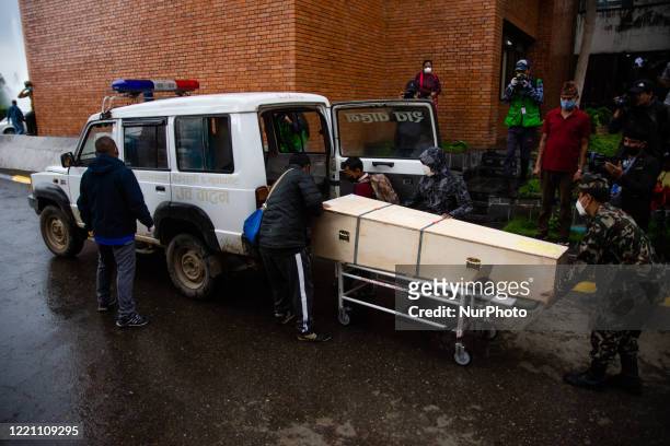People load a coffin carrying body of Nepalese migrant worker who died in Qatar at Tribhuwan International airport in Kathmandu, Nepal on Friday,...
