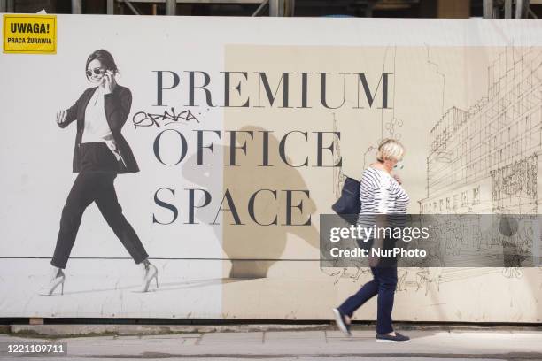 Woman walks past a construction site on June 19, 2020 in Warsaw, Poland.