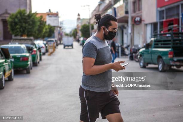 Man wearing a face mask as a preventive measure walks on the street amid Covid-19 pandemic.