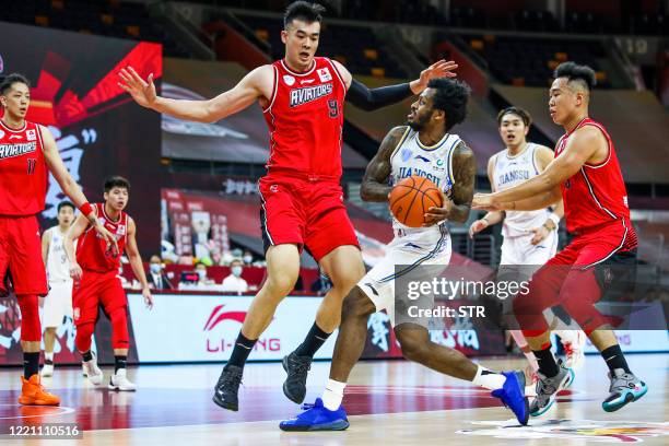 Antonio Blakeney of Suzhou Dragons competes against Li Muhao of Shenzhen Aviators during their CBA basketball match in Dongguan in China's southern...