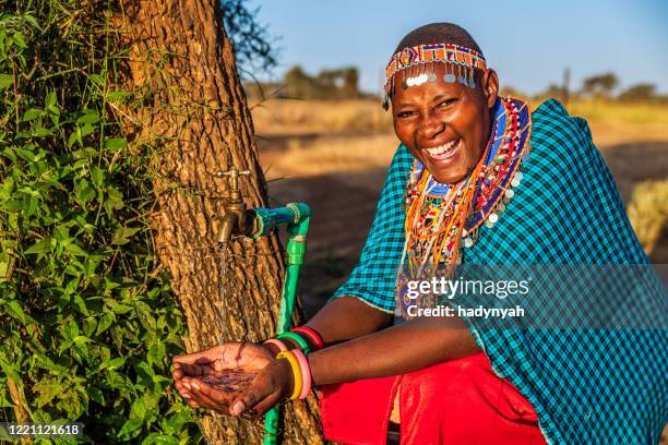 mujer africana de la tribu maasai agua potable, kenia, - a beautiful masai woman fotografías e imágenes de stock