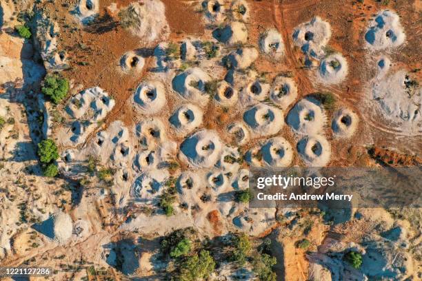 desert landscape with mineshaft holes, white dirt mine tailings on red earth, white cliffs, australia - opal stock pictures, royalty-free photos & images