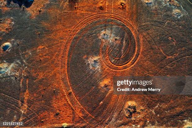 abstract swirl pattern from car tyre tracks in red dirt, illuminated by dusk sunlight, remote rural australia - car decoration stock pictures, royalty-free photos & images