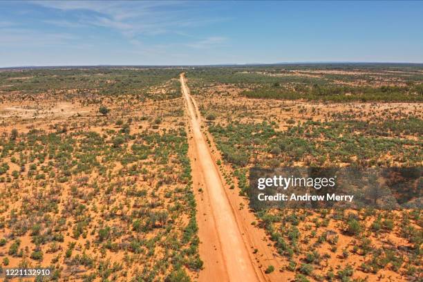 australian landscape with red dirt road and blue sky, road trip in outback australia - new south wales road stock pictures, royalty-free photos & images