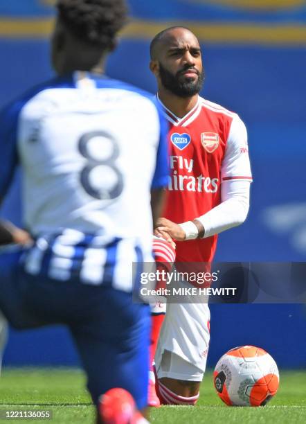 Brighton's Ivorian midfielder Yves Bissouma and Arsenal's French striker Alexandre Lacazette take a knee to show support for the Black Lives Matters...