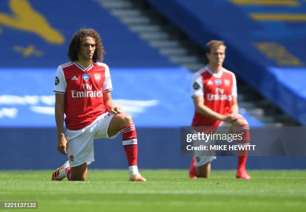Arsenal's French midfielder Matteo Guendouzi takes a knee to show support for the Black Lives Matter movement and as a protest against racism ahead...