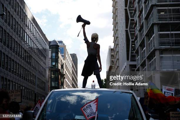 Activist Imarn Ayton stands on top of a car during an anti-racism protest near Trafalgar Square on June 20, 2020 in London, United Kingdom. Black...