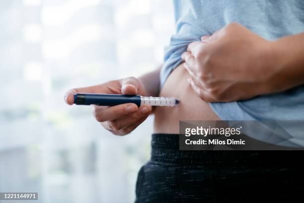 frau macht insulin-injektion in den magen. stockfoto - iv drip womans hand stock-fotos und bilder