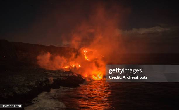 clouds of smoke rise as hot lava pours into the ocean at night - anel de fogo do pacífico imagens e fotografias de stock