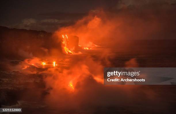 a volcanic coastline on fire with lava at night - anel de fogo do pacífico imagens e fotografias de stock