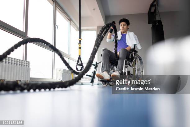 Teenage boy in wheelchair doing rope workout