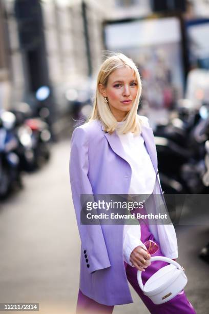 Leonie Hanne wears a mauve oversized blazer jacket, a white shirt, a white bag from Jacquemus, purple leather cropped pants, outside Max Mara, during...