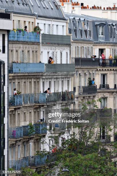People applaud on their balcony at the neighborhood of "Gobelins" during the confinement of the French due to an outbreak of the coronavirus on April...