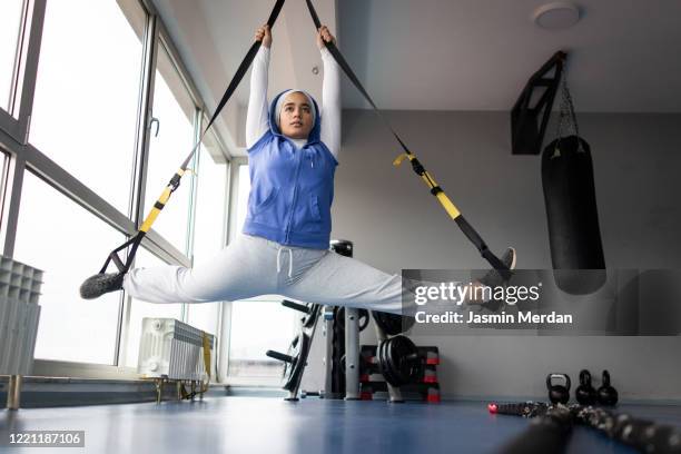 girl in gym stretching legs doing the split - leg stretch girl stock-fotos und bilder