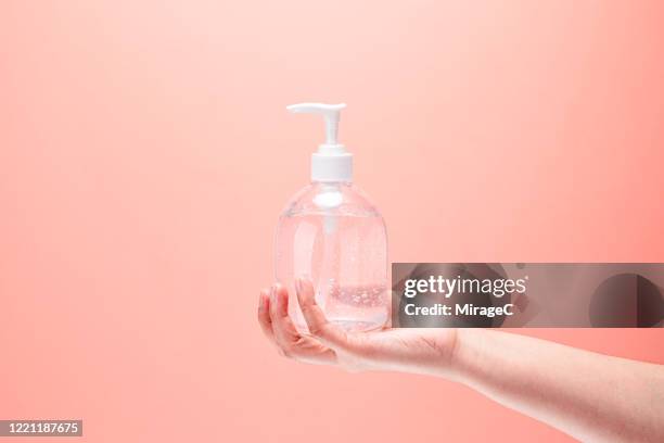 hand holding ethanol alcohol gel hand sanitizer - hand sanitiser stock pictures, royalty-free photos & images