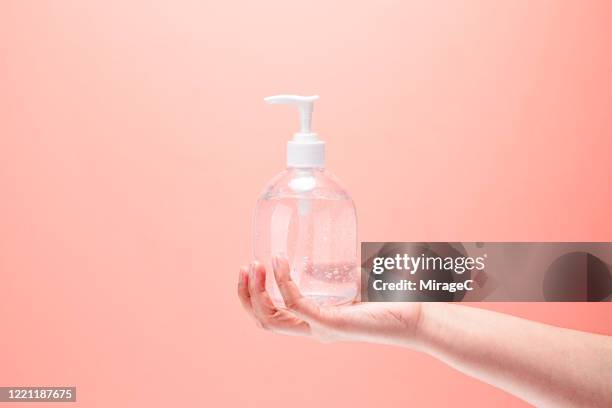hand holding ethanol alcohol gel hand sanitizer - hand sanitiser - fotografias e filmes do acervo