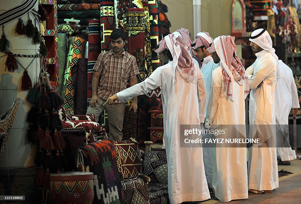 Saudi shoppers check traditional carpets