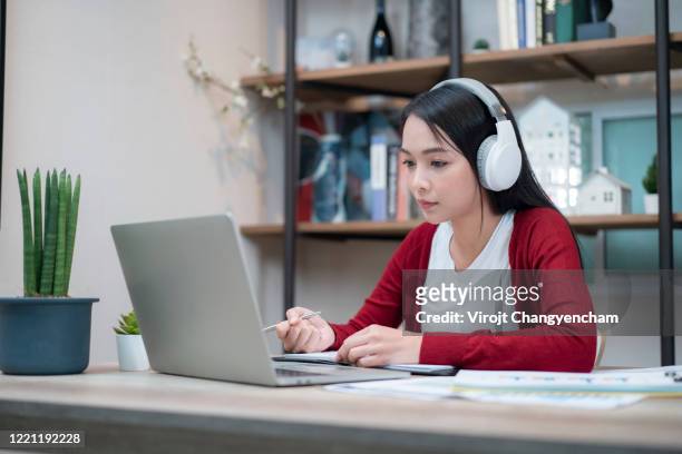 asian female working at home with headphone for video conference - girl in office stock pictures, royalty-free photos & images