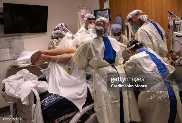 Prone team," wearing personal protective equipment , turns a COVID-19 patient onto his stomach in a Stamford Hospital intensive care unit , on April...