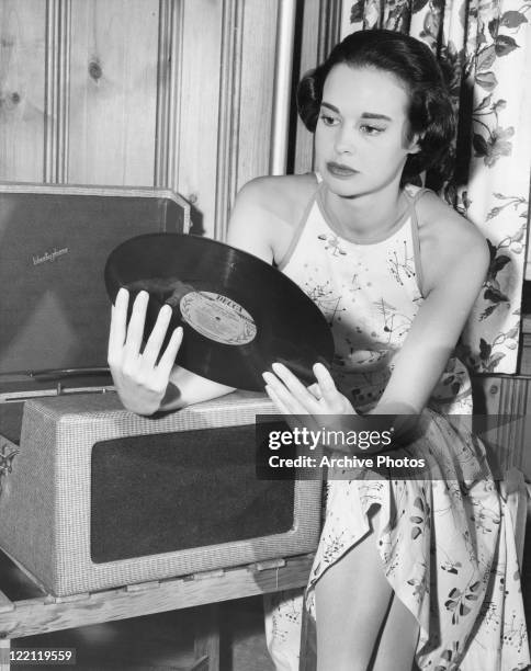 American socialite, fashion designer, actress, writer and artist Gloria Vanderbilt with a Decca long-play record by Richard Tauber entitled 'Songs of...