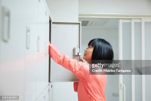 mature sportswoman in a locker room - locker room ストックフォトと画像